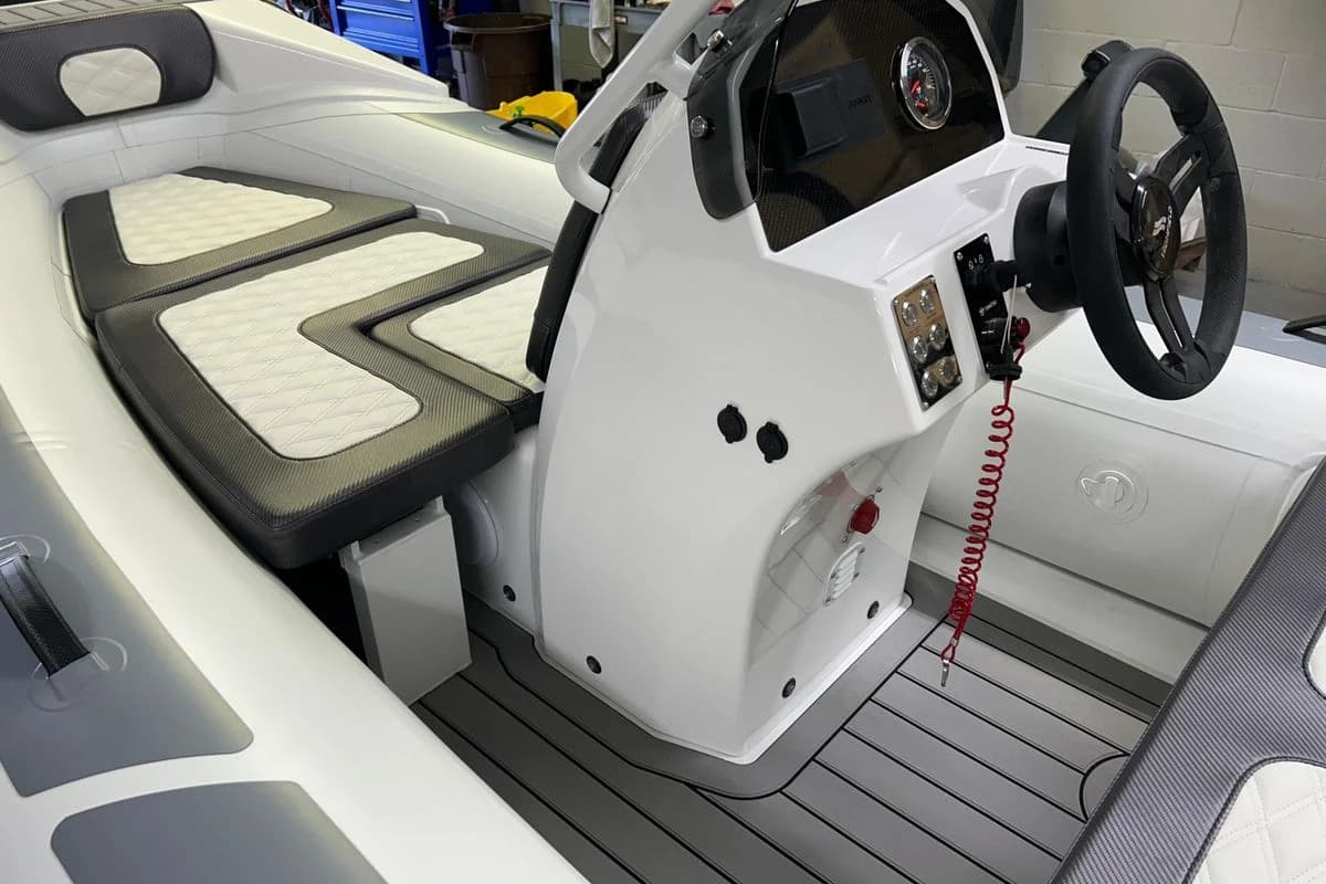 2025 Highfield Sport 390 boat interior with steering console and cushioned seating.