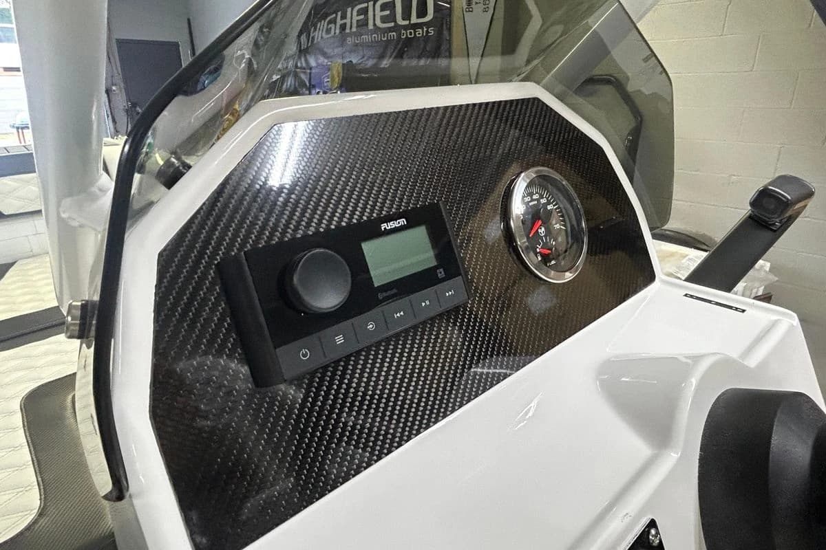 Dashboard of 2025 Highfield Sport 390 boat with carbon fiber finish and control panel.