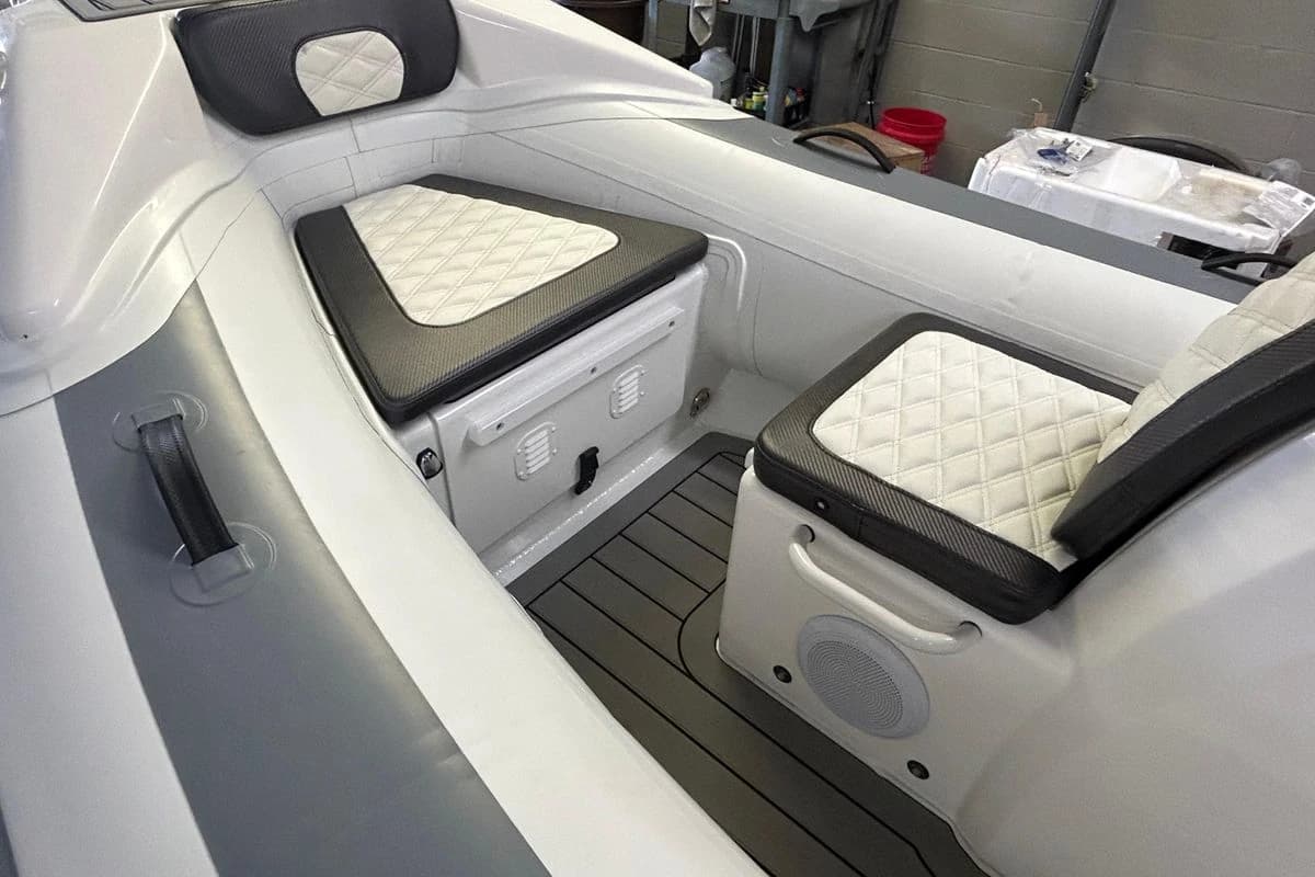 Interior of 2025 Highfield Sport 390 boat with cushioned seating and storage compartments.
