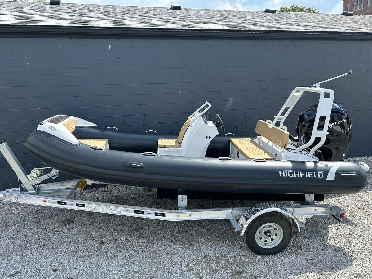 2025 Highfield Sport 460 inflatable boat on trailer, parked outdoors.