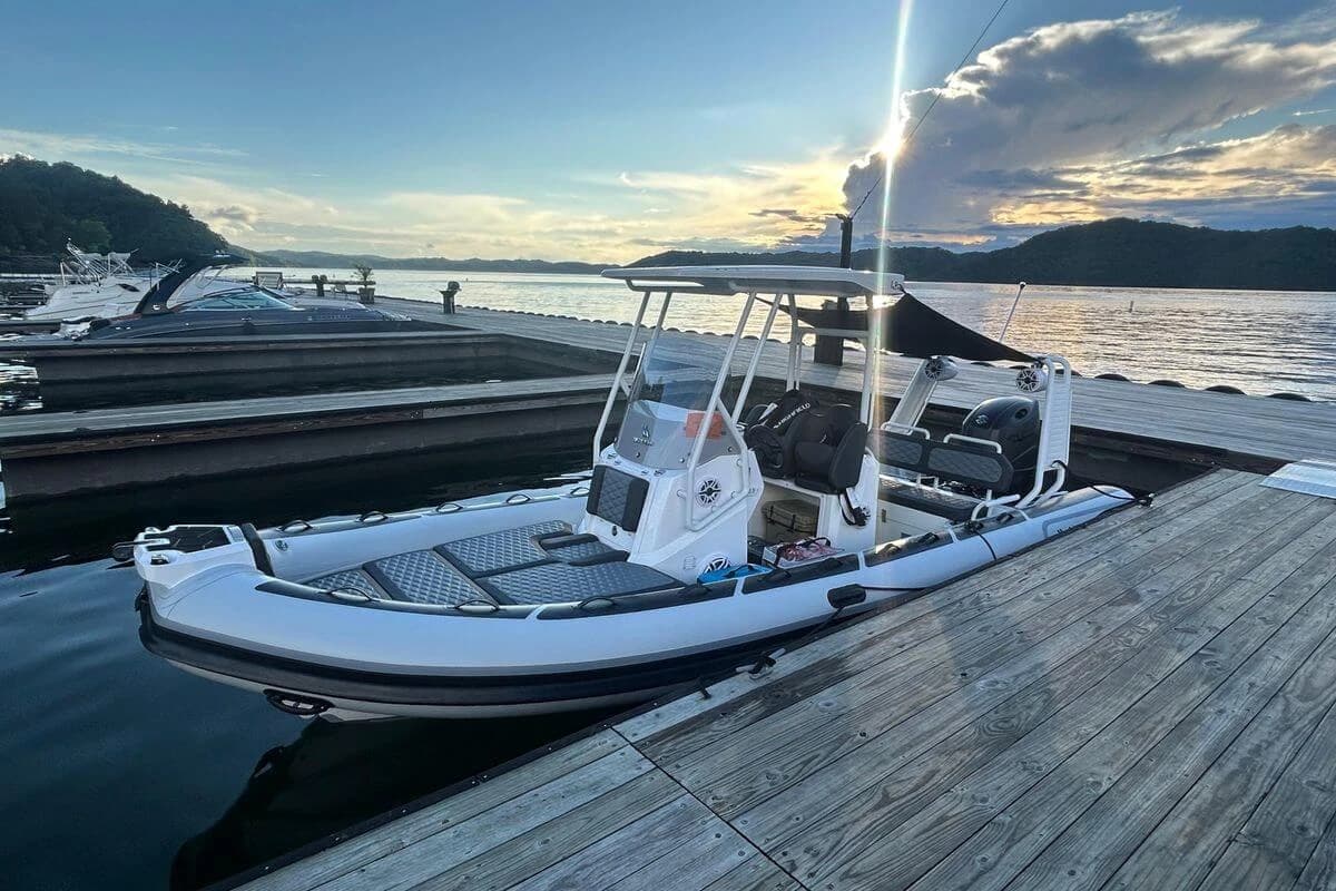 2025 Highfield Sport 660 boat docked at sunset, with scenic water and sky backdrop.
